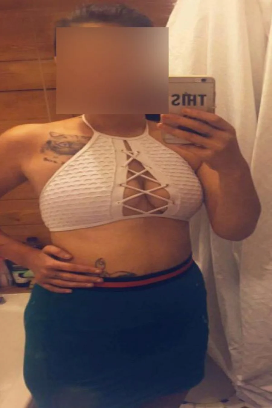 Linda taking selfie in the mirror in white revealing top