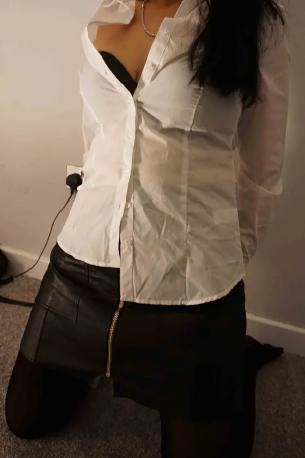 Hanna wearing a white shirt and black skirt