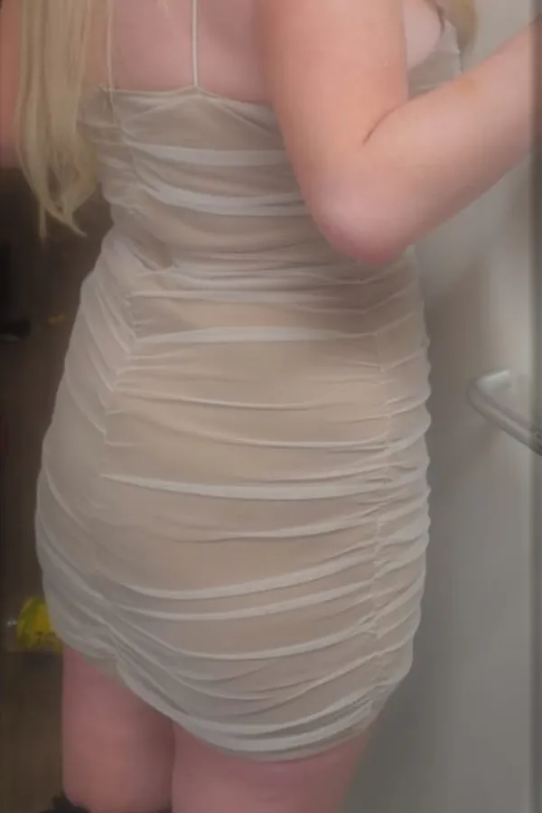 Kylie standing in a white dress 